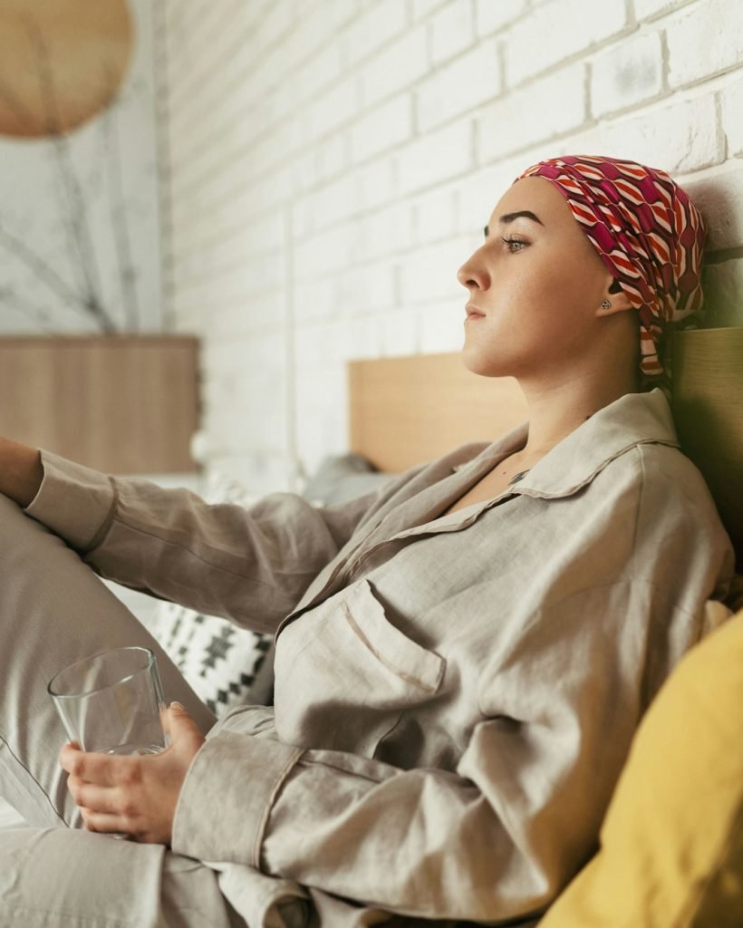 Young woman with cancer taking pills, cancer awareness concept.